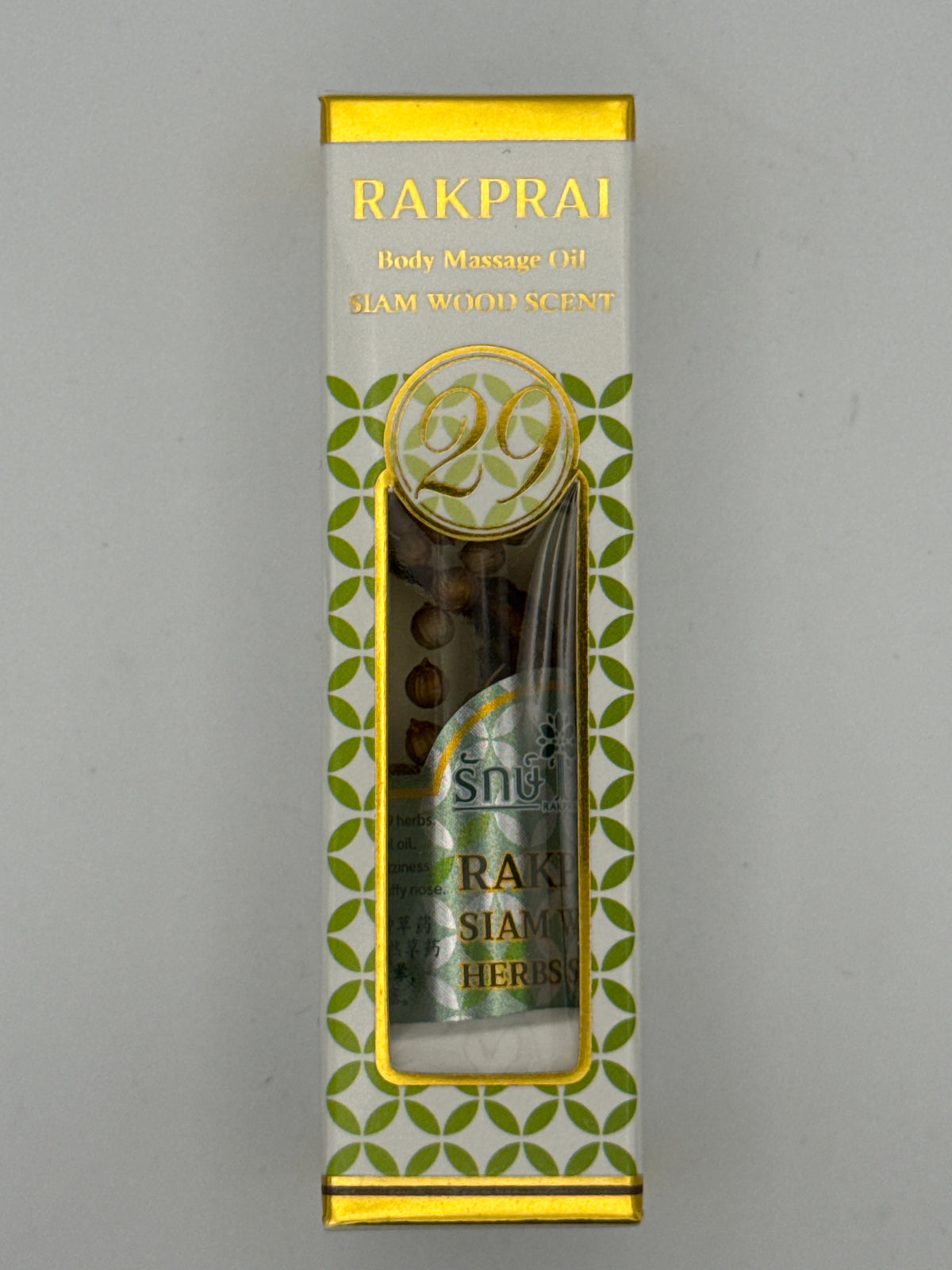 Front photo: Rakprai Body Massage Oil Siam Wood Scent box with gold trim, green pattern, and bottle visible through the front window.