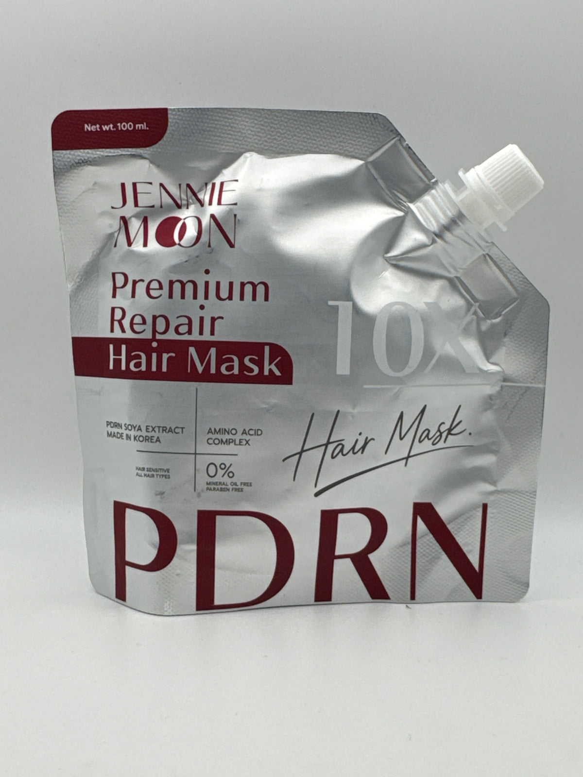 Jennie Moon 10X PDRN Premium Repair Hair Mask, 100 ml silver pouch with burgundy lettering and white spout cap.