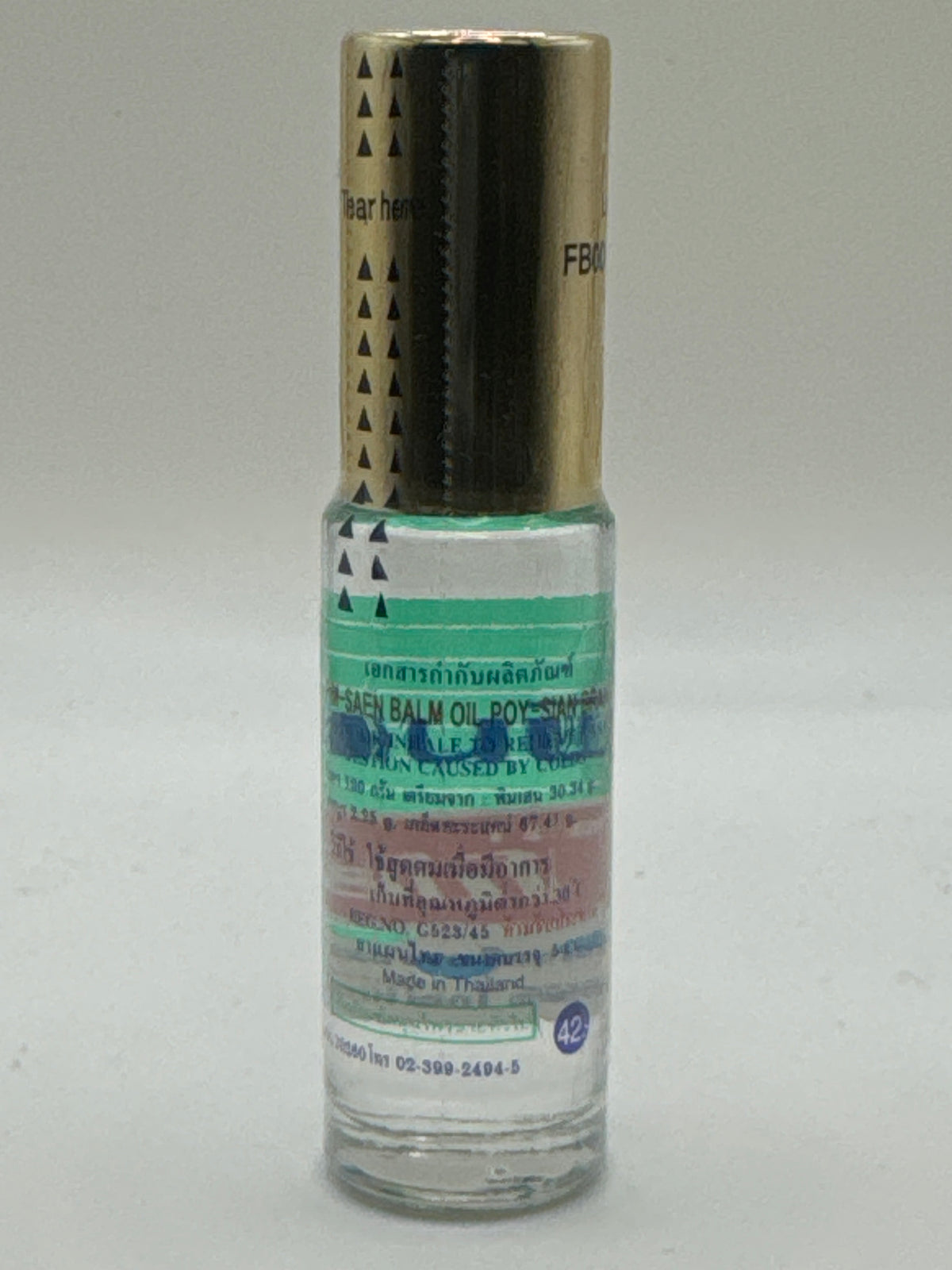 Poy Sian Pim Saen Balm Oil bottle, back view showing Thai and English product information and Made in Thailand label.