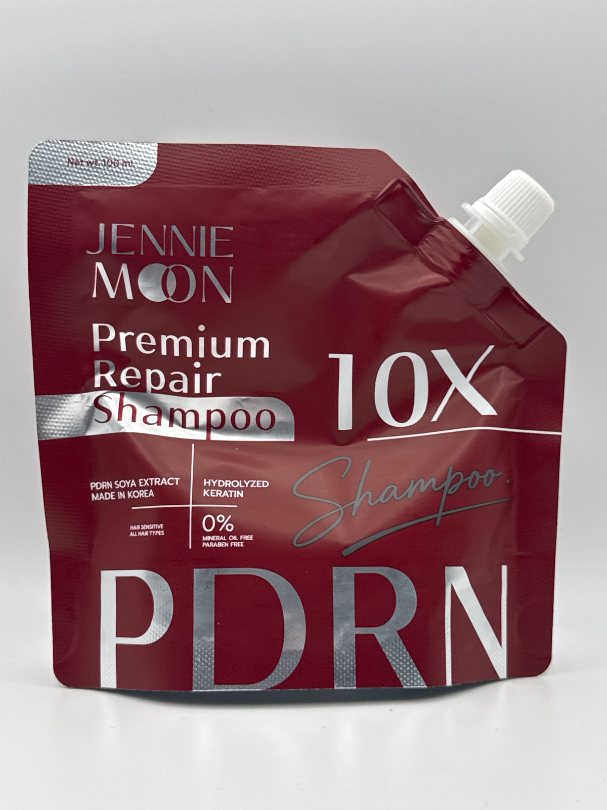 Jennie Moon 10X PDRN Premium Repair Shampoo, 100 ml burgundy pouch with silver lettering and white spout cap.