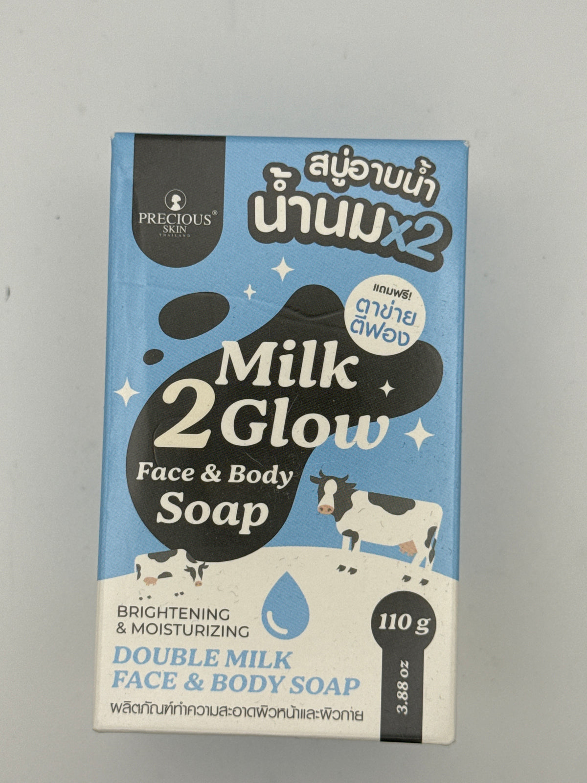 Front: Precious Skin Milk 2 Glow Face and Body Soap 110 g box with blue packaging and cow illustrations.